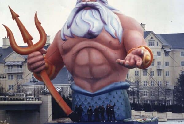 Massive hand-painted inflatable artwork of King Triton, created by Air Artists and commissioned by Disney for the grand opening of Euro Disney Paris in April 1992, floating on water with buildings in the background.